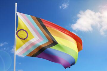 Wehende Prideflag vor blauem Himmel