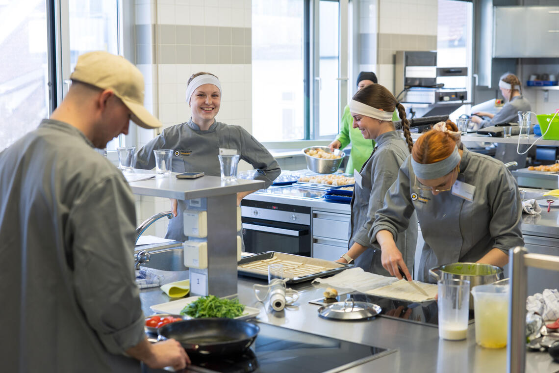 Studierende in der Lehrküche beim Kochen