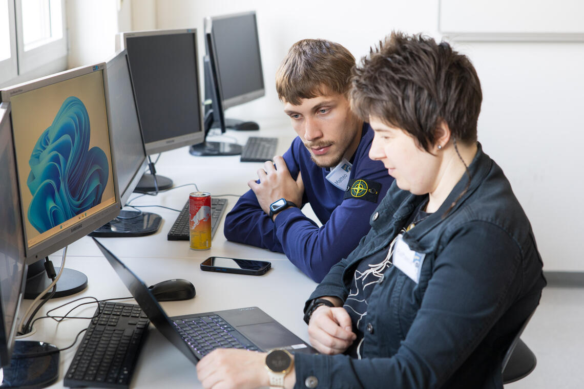 Mann und Frau sitzen vor Computern