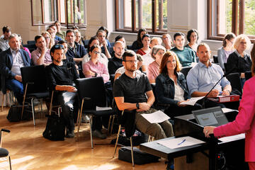 Gruppe sitzt in der Aula