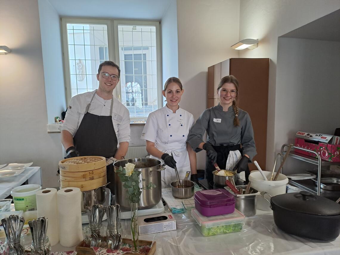 3 Studierende bereiten Hauptgang vor 