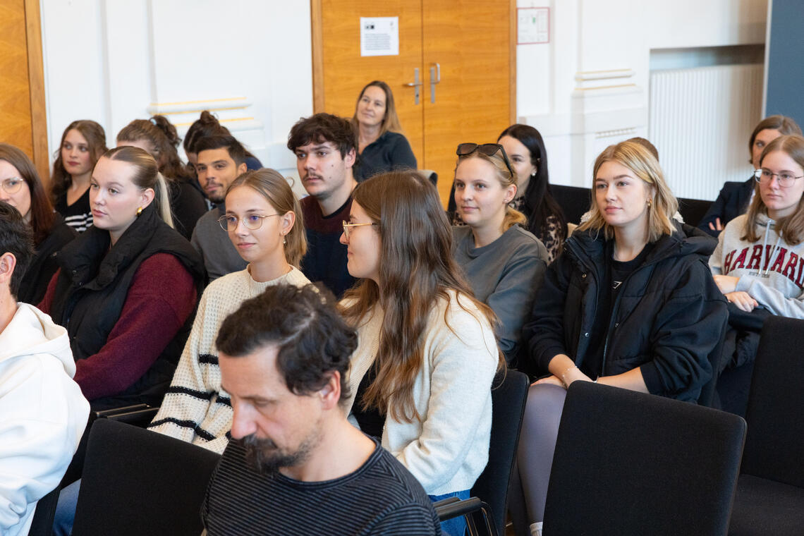 Frauen und Männer sitzen im Publikum 