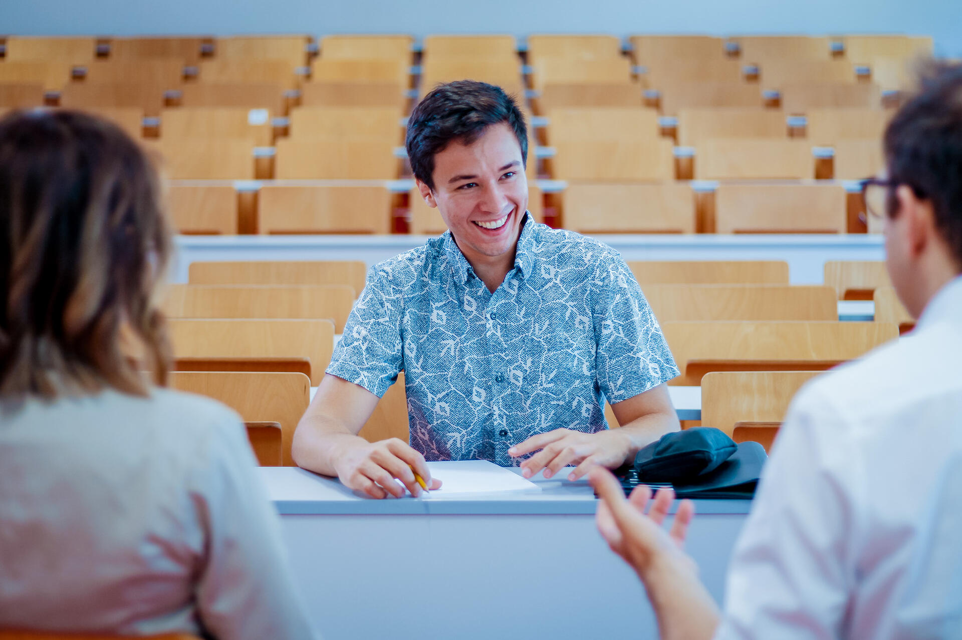 Student sitzt 2 Personen gegenüber